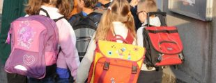 Des enfants avec un cartable sur le dos allant à l'école
